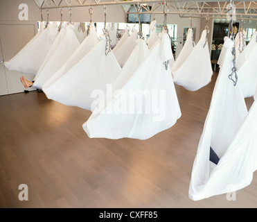 Aerial yoga class in progress at fitness center Stock Photo