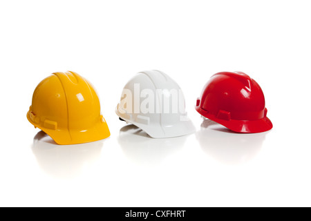 Row of yellow, white and red construction hardhats on a white background Stock Photo