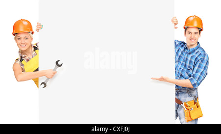 Two construction workers standing behind panel isolated on white background Stock Photo