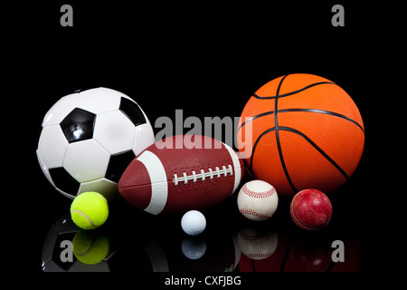 Assorted sports balls on a black background Stock Photo - Alamy