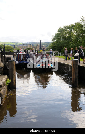 Two narrowboats exit the top chamber of Bingley Five-Rise Locks, on the Leeds and Liverpool Canal in Bingley, Yorkshire, England Stock Photo