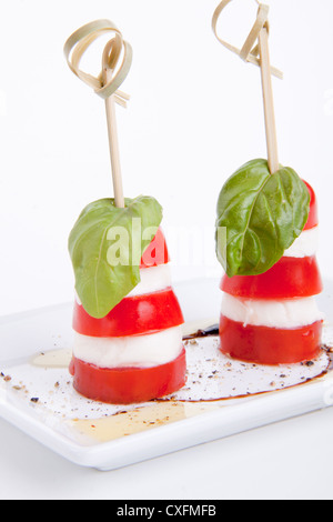 tasty tomatoe mozarella salad with basil isolated on white background Stock Photo