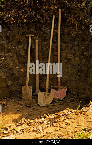 hole for a garden pond with shovel,spade and hoe Stock Photo