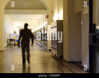 Student in a hallway with lockers at the University Stock Photo