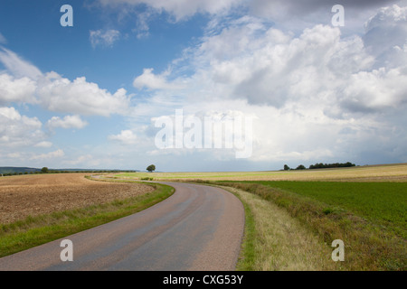 A road leading through agricultural fields under a big sky in Burgundy Northern France Stock Photo