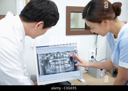 A dentist and a nurse watching teeth x-ray picture in a computer Stock Photo