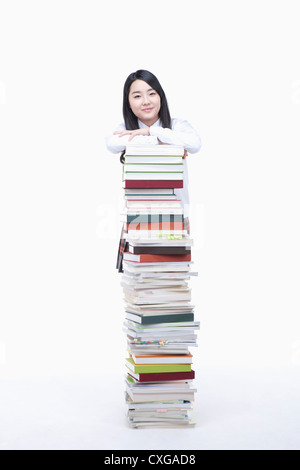 schoolgirl standing behind a stack of books Stock Photo - Alamy