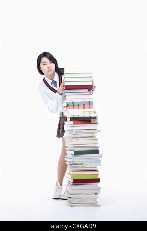 schoolgirl standing behind a stack of books Stock Photo - Alamy