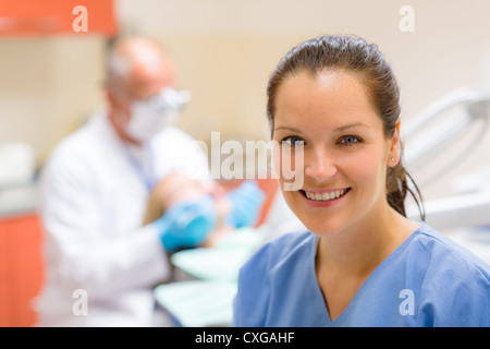 Female dental assistant smiling at stomatology office dentist with patient Stock Photo
