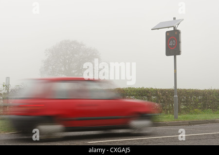 Speeding motorists passing through an activated radar warning at 40mph cruising above seed limit poor visibility due to mist Stock Photo