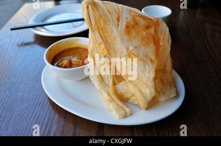 Roti canai, Indonesian and Malaysian, a pancake with curry dipping  sauce Stock Photo