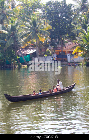 A family outing in a wooden tradition canoe through the backwaters of Alleppey, Kerala, India. Stock Photo