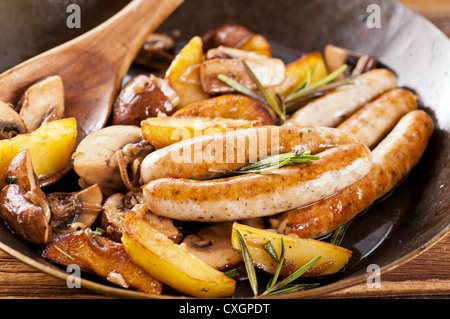 Fried sausages with potatos and mushrooms Stock Photo