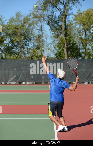 Mature man playing tennis on court Stock Photo