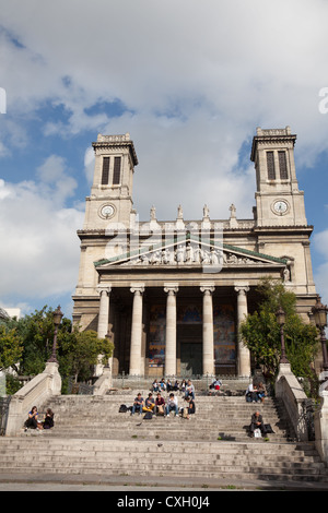 People sitting on steps in front of l'Eglise Saint Vincent de Paul (completed 1844) in central Paris. Vincent had worked there. Stock Photo