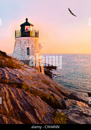 Herring gull laurus flies over Castle Hill lighthouse at twilight sunset over Narragansett Bay Newport Rhode Island New England Stock Photo