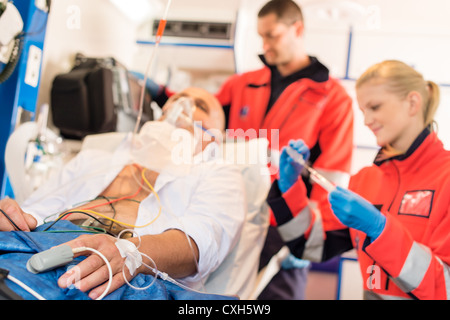 Sick patient with paramedics in ambulance treatment aid emergency work Stock Photo