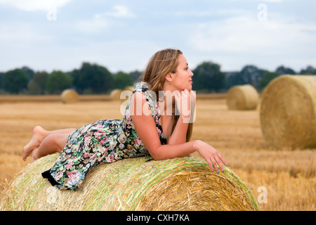 Woman  sitting on hay bale Stock Photo