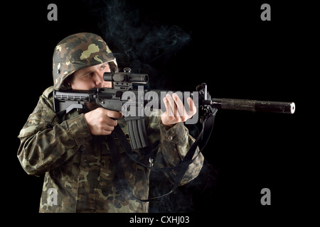 Alerted soldier keeping a smoking gun Stock Photo