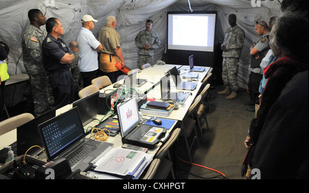 Lt. Col. Thomas Brown, team leader, U.S. Army Pacific Contingency Command Post Humanitarian Assistance Survey Team explains the HAST capabilities to members of the Tonga National Emergency Management Office, government officials, and non-government organizations at Taliai Military Camp, Kingdom of Tonga, Sept. 25, 2012. They are taking part in â€œCoral Reefâ€ a multi-national emergency deployment readiness exercise to share humanitarian assistance and disaster relief techniques and procedures with Pacific partners from Australia, New Zealand and Tonga. Stock Photo