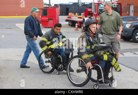 NEW YORK – Richard Hickley, a retired fire chief from the Fire Department of the City of New York, Peter Park, a resident of Champaigne, Ill., Nick Beach, a resident of Dresden, Ohio, and Gunnery Sgt. Sam Erwin, the company gunnery sergeant for Headquarters Company, 6th Communications Battalion, 4th Marine Logistics Group, move to the first firefighter training event put on for wounded warriors. Park, Beach and a group of other wounded warriors visited the New York City Fire Academy located on Randall's Island on Sept. 29. Stock Photo