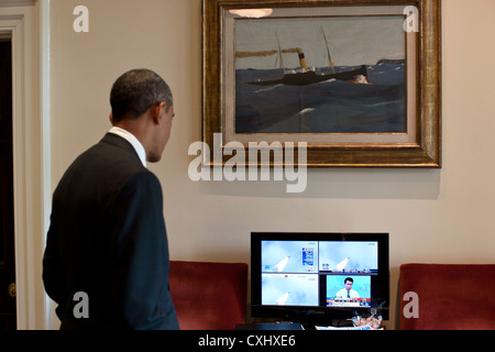 US President Barack Obama watches the launch of the Space Shuttle Atlantis on a television monitor July 8, 2011 in the Outer Oval Office of the White House. Stock Photo