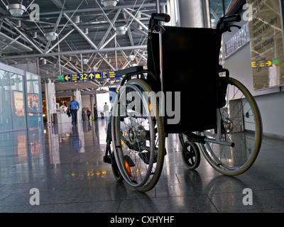 Empty wheelchair for disabled passengers  on airport concourse Stock Photo