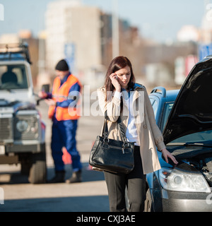 Woman on the phone after car crash breakdown talking upset Stock Photo