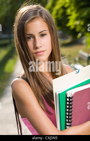 Outdoors portrait of a beautiful tanned teen student girl. Stock Photo