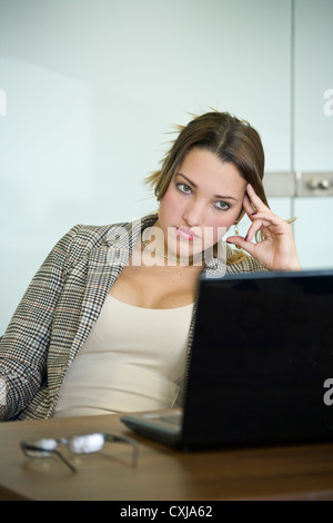 Young office worker leaning back in chair looking fed up. Stock Photo