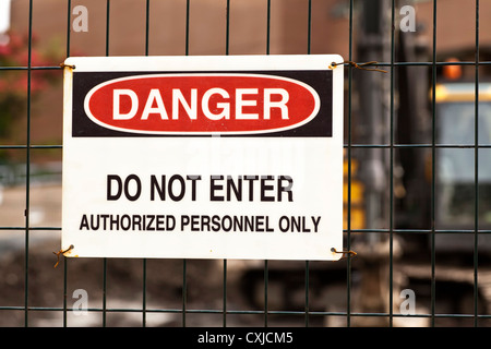 Danger sign at a work site with heavy equipment in the background. Stock Photo