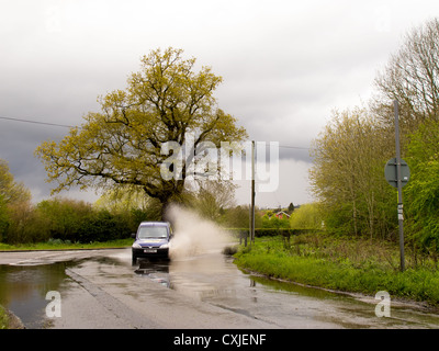 Flooding on a country road near Nutfield marsh causing problems for cars Stock Photo