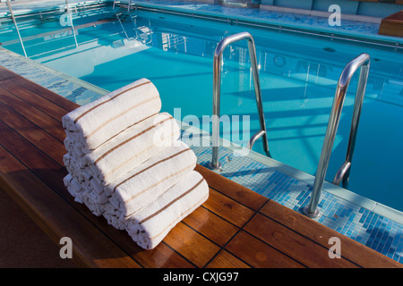 Prepared towels next to empty Swimming Pool. Cunard Liner Queen Victoria. Stock Photo