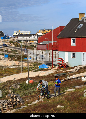 Local boys ride a bike and play at Ilulissat, with 4,000 people, the third largest town in Greenland Stock Photo