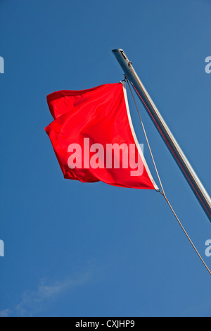 Red flag flying in blue sky, indicating limit of save bathing area on beach, Salou, Spain Stock Photo