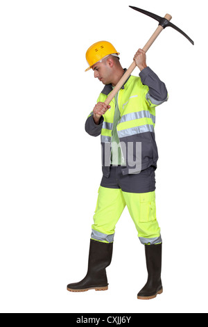 Laborer using pickaxe on white background Stock Photo