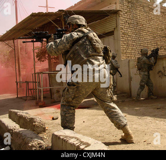 US Army soldiers from the 1st Stryker Brigade Combat Team return fire on insurgents March 14, 2007 in Buhriz, Iraq. Stock Photo