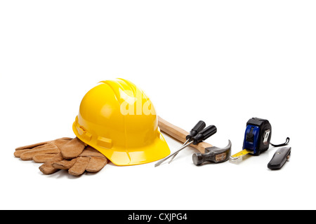 Yellow hard hat with leather gloves and various tools on a white background Stock Photo