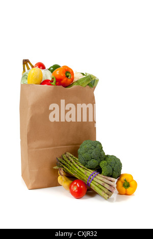 fresh organic vegetables in brown paper bag against dark table ...