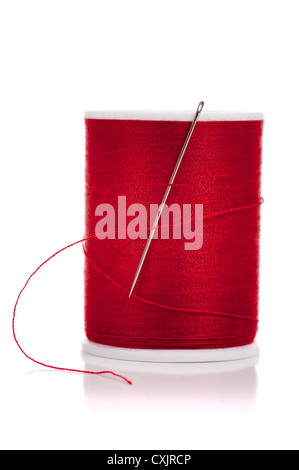 Spool of red thread and a needle on a white background Stock Photo