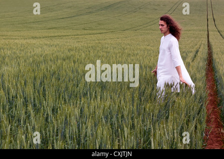 Spiritual daydreamer striding through a cornfield Stock Photo