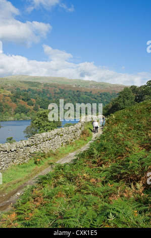 People visitors tourists walkers on footpath along Loughrigg Terrace walk Rydal Water in summer Cumbria England UK United Kingdom GB Great Britain Stock Photo
