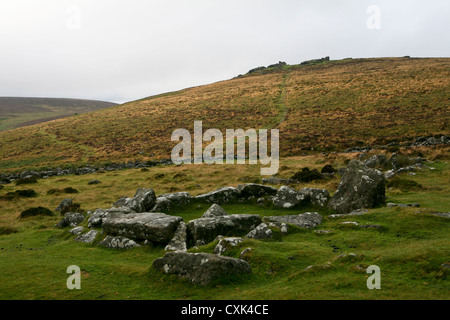 Hut circle at Grimspound, a Bronze Age settlement, with Hookney Tor visible, Dartmoor National Park, UK Stock Photo