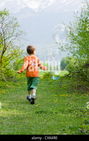 Boy Running and Blowing Bubbles, Salzburg, Austria Stock Photo