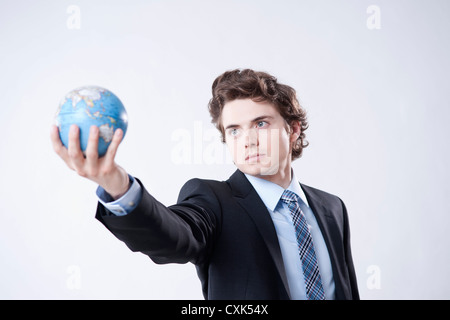 Portrait of Young Businessman holding World Globe Stock Photo