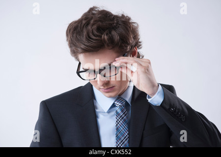 Portrait of Young Businessman Looking Down and wearing Eyeglasses Stock Photo