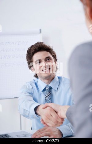 Young Businessman Shaking Hands with Businesswoman Stock Photo