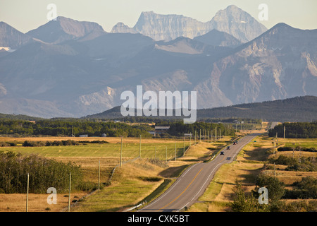 Rural Road and Rocky Mountains, Pincher Creek, Alberta, Canada Stock Photo
