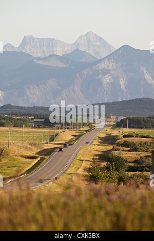 Rural Road and Rocky Mountains, Pincher Creek, Alberta, Canada Stock Photo