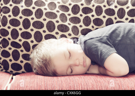 Boy (4-5) sleeping on couch, France. Stock Photo